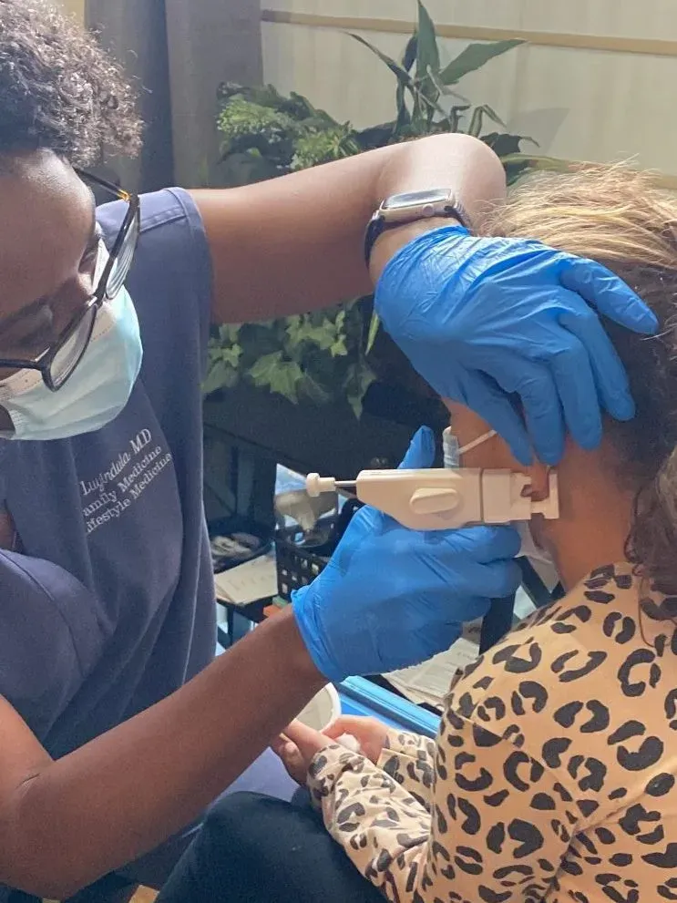 Child receiving a gentle medical ear piercing